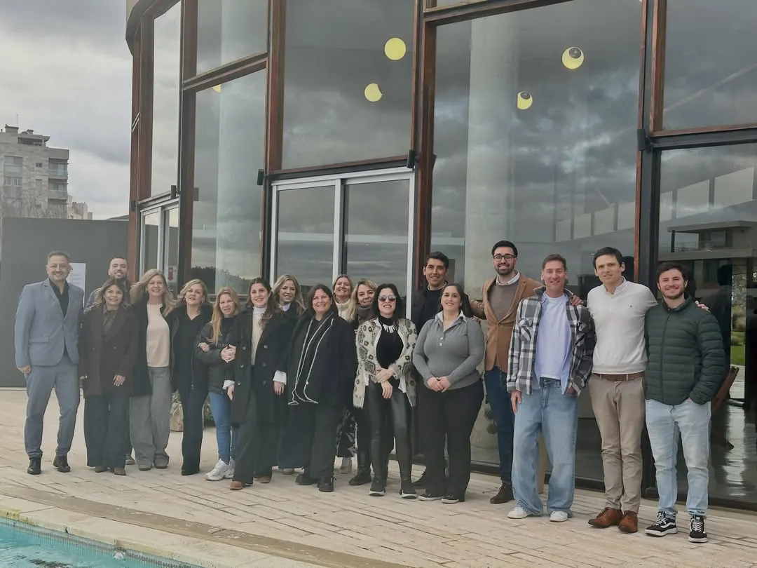 El equipo de Infinity Real Estate, de pie frente a un ventanal